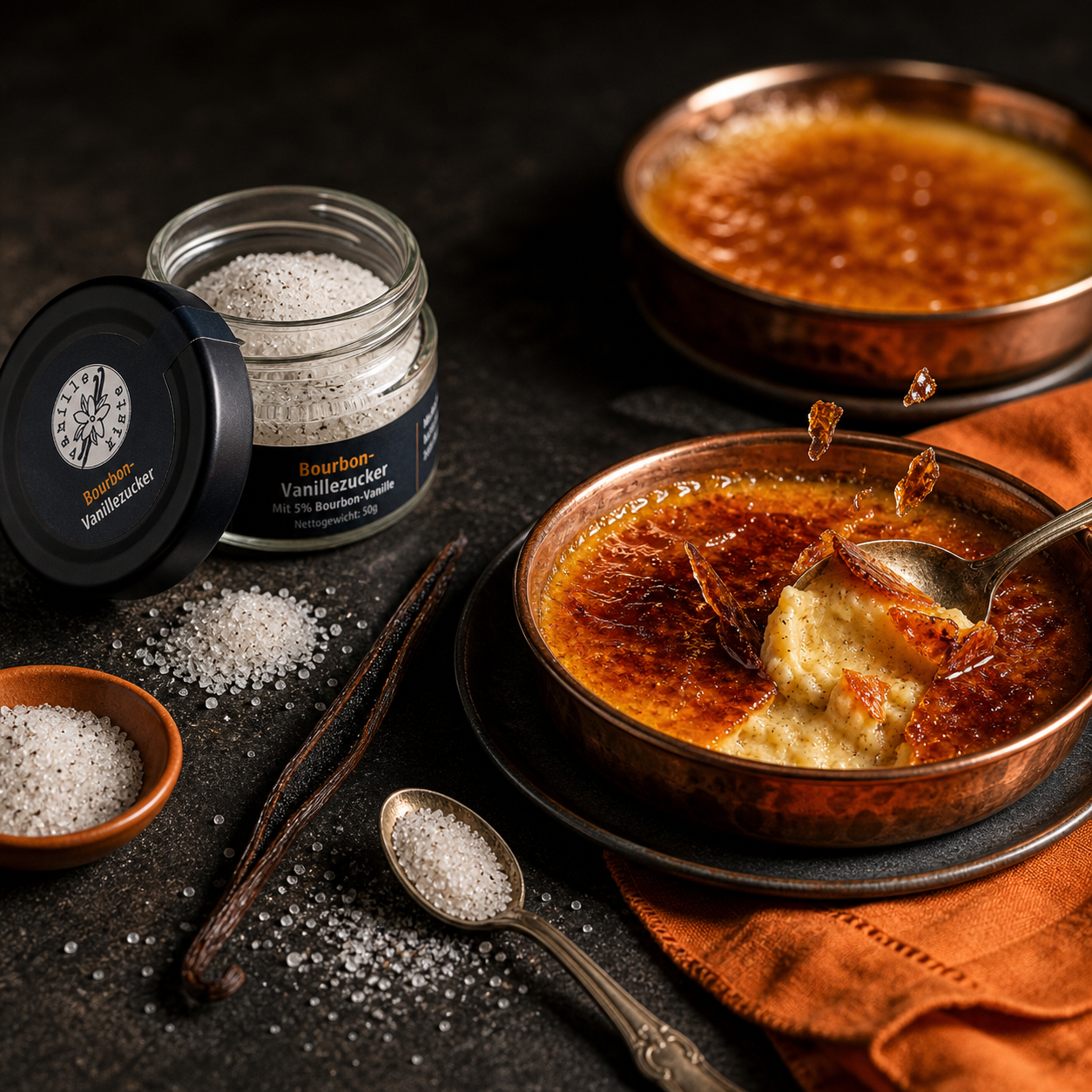 Crème brûlée mit karamellisierter Zuckerkruste, daneben ein Glas Bourbon-Vanillezucker und Vanilleschoten